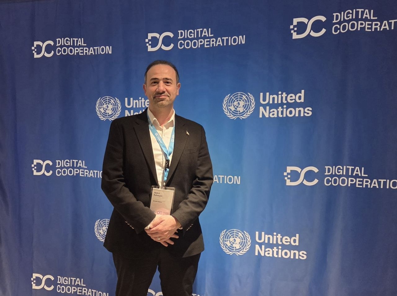 Abdulkader Rahmani in front of a Digital Cooperation and United Nations backdrop